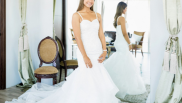 young woman trying on wedding gown