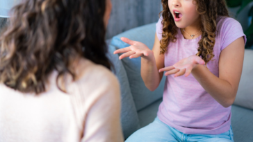 mother and daughter seated on couch arguing