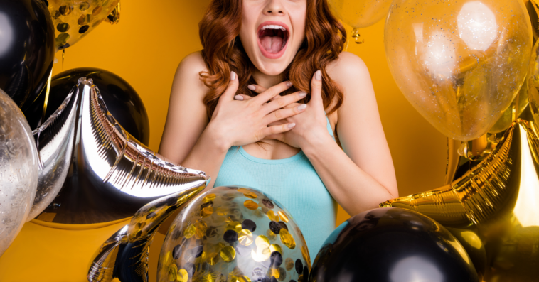 woman surrounded by balloons acting surprised