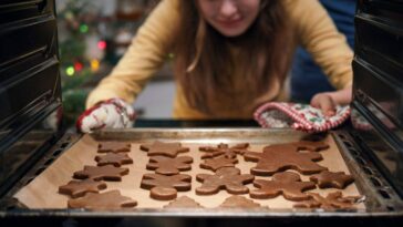 Teenage Girls Baking Christmas Cookies in the Oven.