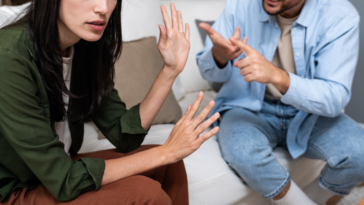 A couple sitting on a sofa having an argument