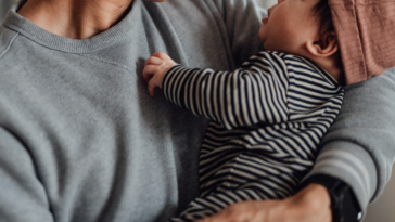 A father holding a baby.