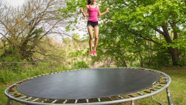 A young girl in mid air after jumping on a trampoline.