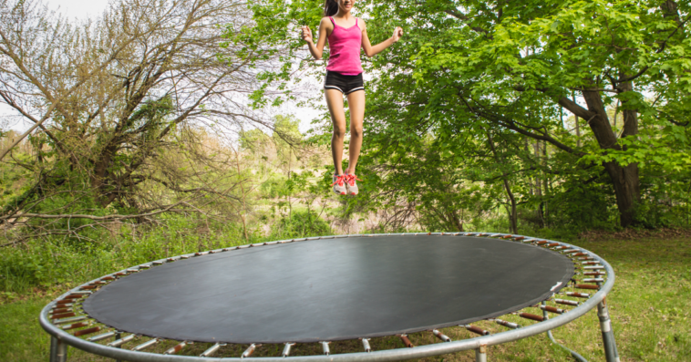 A young girl in mid air after jumping on a trampoline.