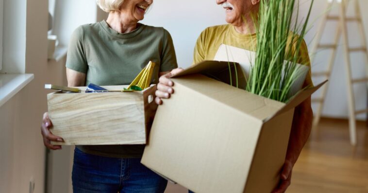 Happy senior couple talking while moving into a new home.