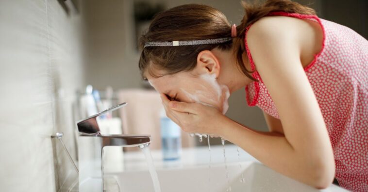 Teen girl washing her face