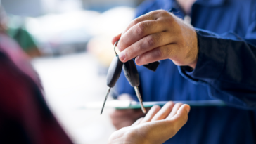 A person passing car keys to someone else