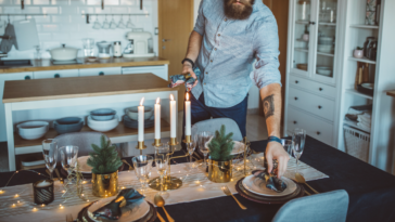 A man setting the dinner table.