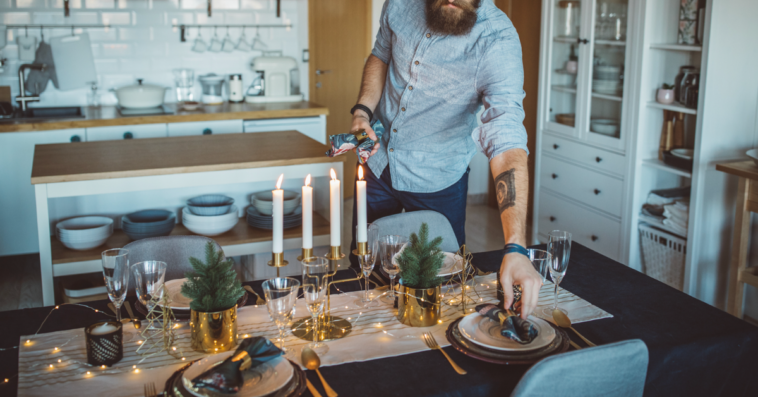 A man setting the dinner table.