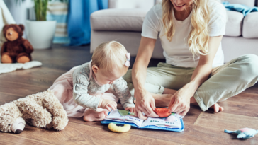 A young woman sitting on the floor playing with a young child.