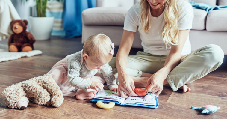 A young woman sitting on the floor playing with a young child.