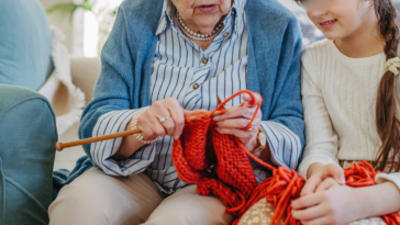 older woman showing child how to knit