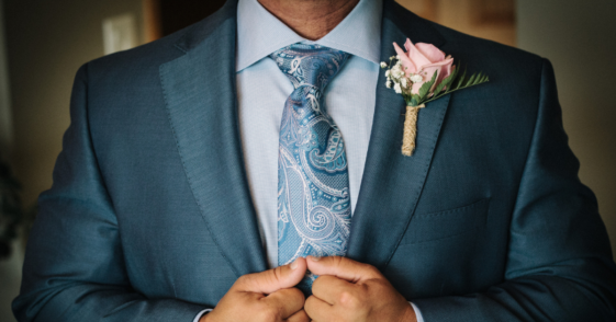 man adjusts suit lapels