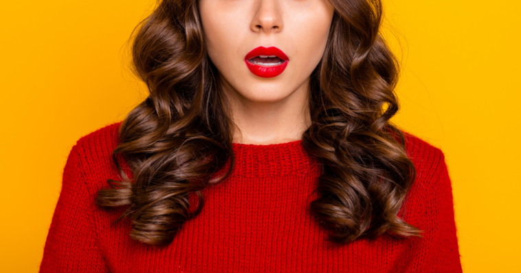 brown haired woman in red sweater with shocked expression