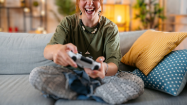 woman seated on couch playing video game