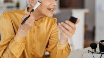 older woman applying makeup