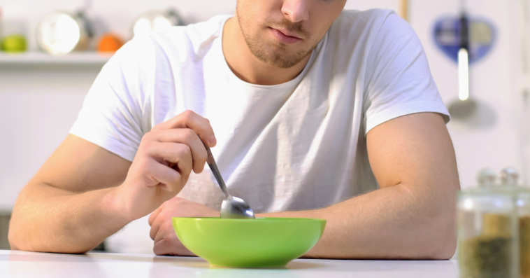 unhappy man with a bowl of stew