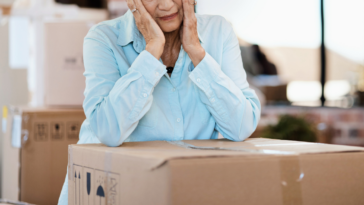 upset older woman with moving boxes