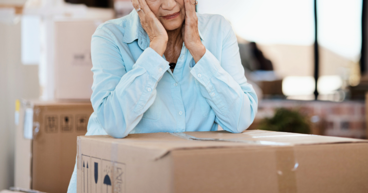 upset older woman with moving boxes