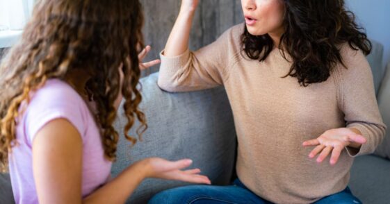 Woman argues with her teenage daughter while sitting at home.