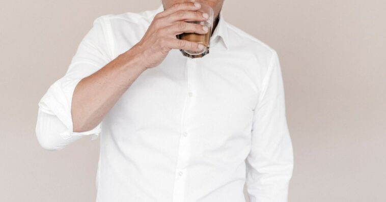 Businessman drinking a latte from a glass.