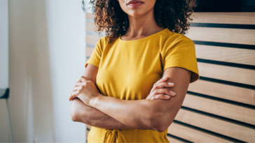 Woman in yellow shirt with her arms crossed