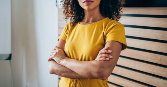 Woman in yellow shirt with her arms crossed