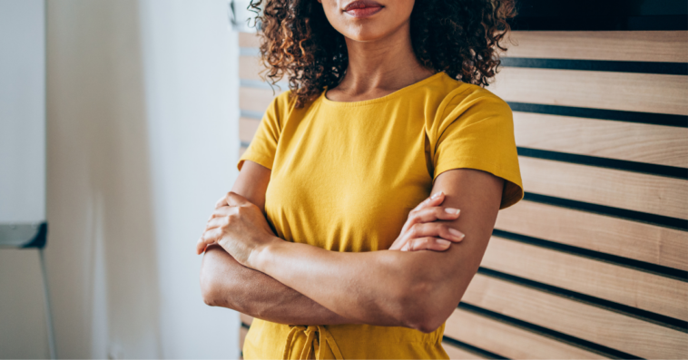 Woman in yellow shirt with her arms crossed