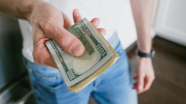 A man holding a wad of cash.