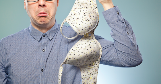 A man holding a polka dotted bra.