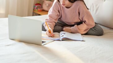 Young girl studying on the bed