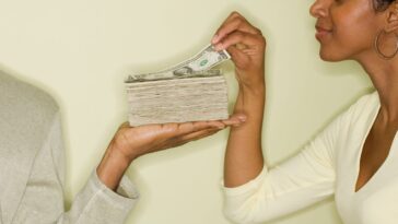 Woman taking money from stack in husband's hand
