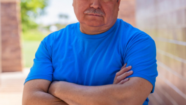 frowning older man with arms crossed