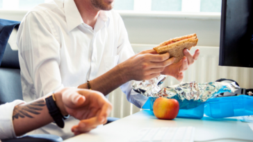 Two male coworkers eating lunch together