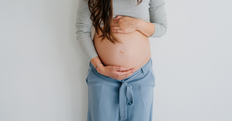 A pregnant woman holding her belly.