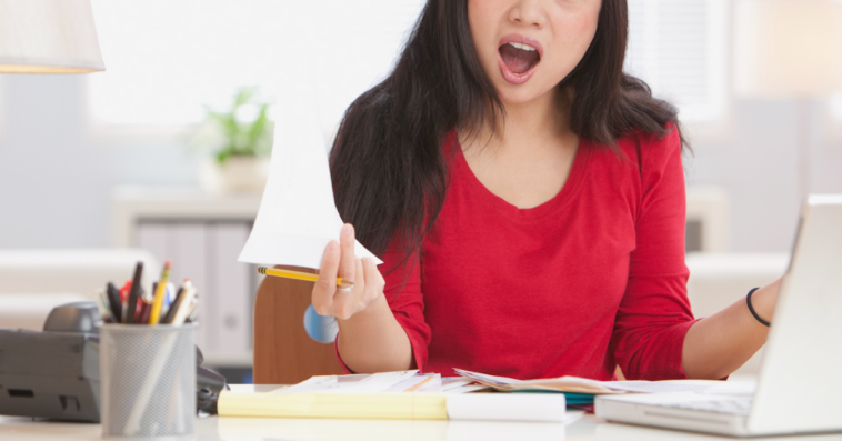 A woman sitting at her desk with an annoyed expression on her face.