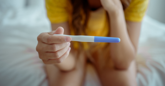 Woman looking at a pregnancy test