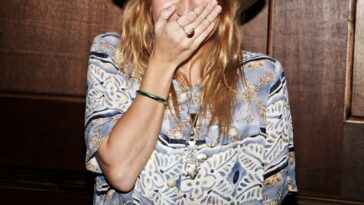 A young woman stifles a laugh while looking into the camera.