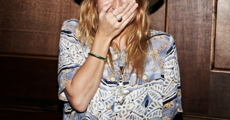 A young woman stifles a laugh while looking into the camera.
