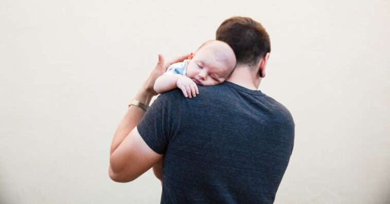 Man holding infant over the shoulder