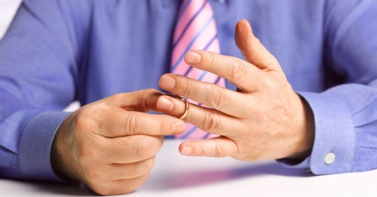 Man removing wedding ring from his finger