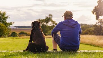 Man sitting with his dog out in nature