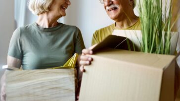 Grandparents carrying moving boxes
