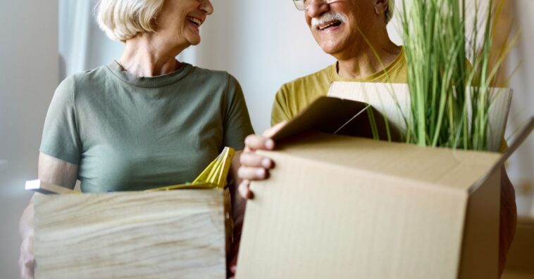 Grandparents carrying moving boxes
