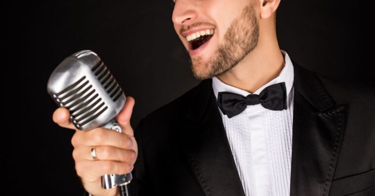 Man in tux singing into mic