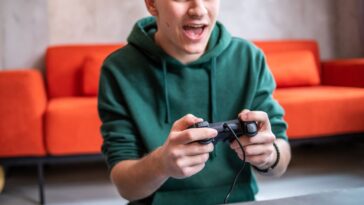 Teenager playing video game