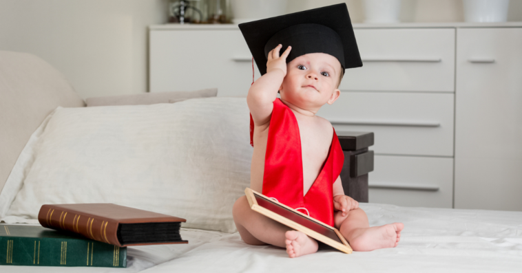 A baby wearing a graduation cap and sash.