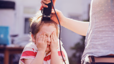 young boy getting head shaved