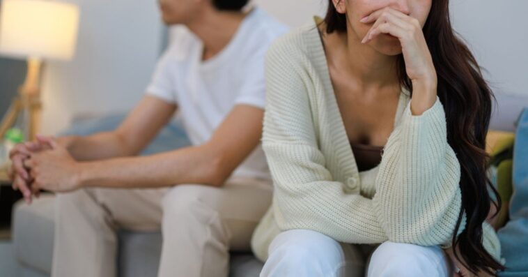 Emotional Couple Expressing Frustration and Upset in Bedroom Argument.