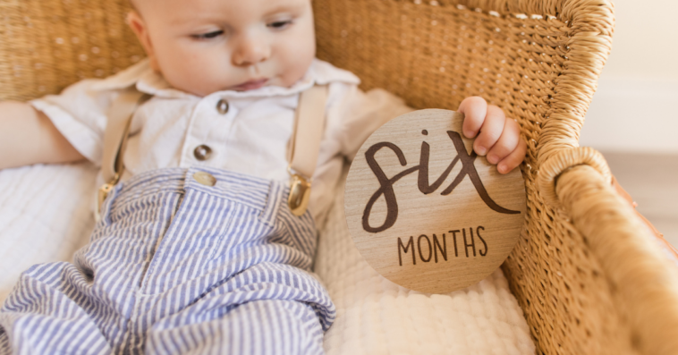 baby in bassinet with six months plaque